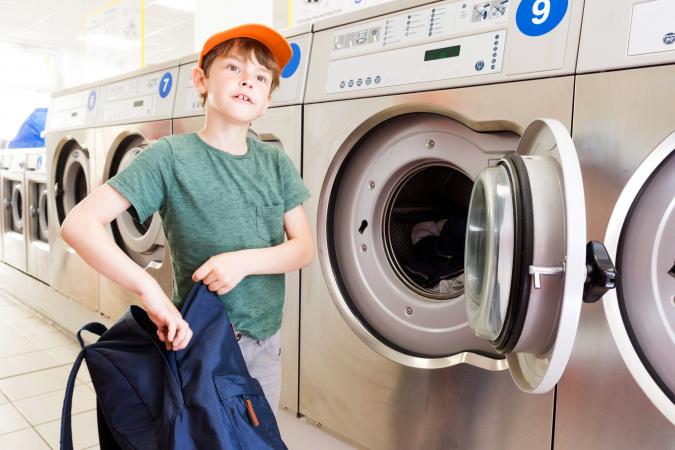Boy Washing is backpack with a washing machine