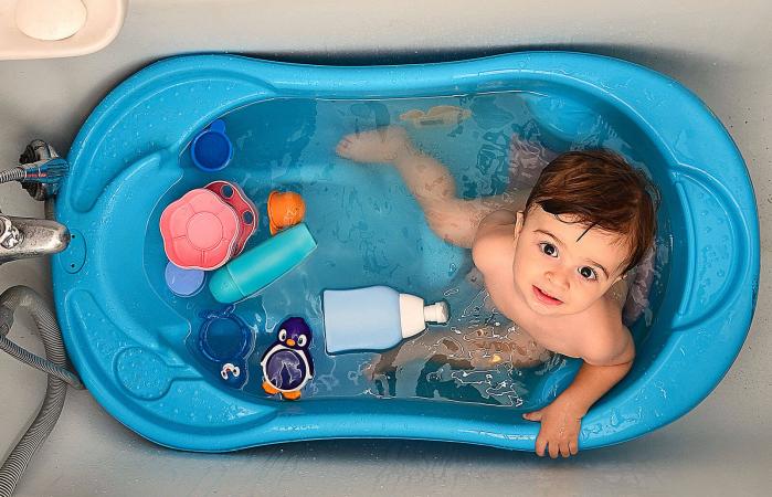 baby in tub with toys