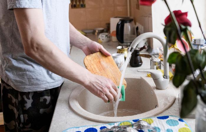 man washing cutting board