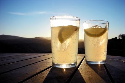 Two brandies rebujito on table against blue sky
