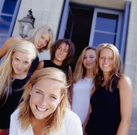 Group of college women in front of house