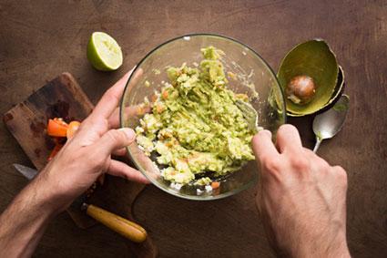 Mashing vegetables to make guacamole
