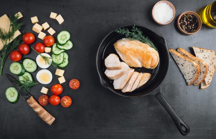 Sliced chicken breast on cast iron pan