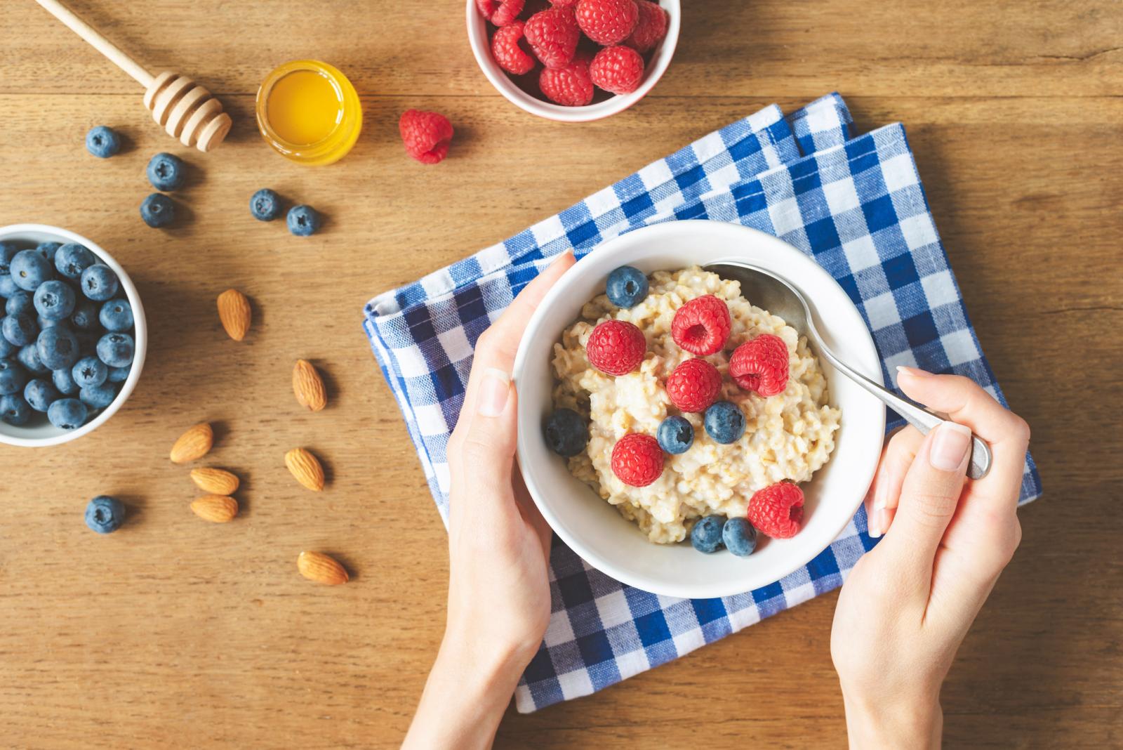 Oatmeal Porridge With Berries In Hands