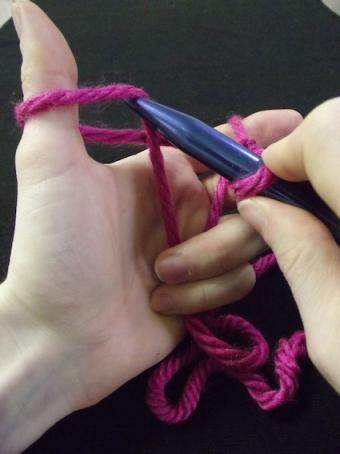 Step two of casting on: Poking one needle under the first loop of yarn.
