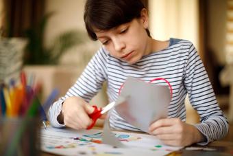 Girl cutting paper for craft project