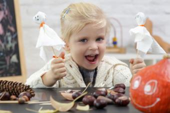 toddler girl with Halloween craft tissue ghost