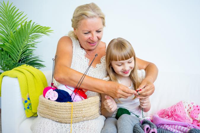 Grandmother knitting with granddaughter