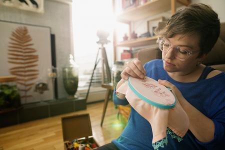 Focused woman doing cross-stitching project