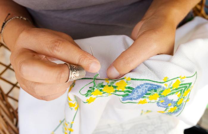 Midsection Of Woman Embroidering On Fabric