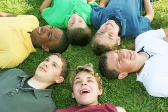 Boys lying on the grass in a circle