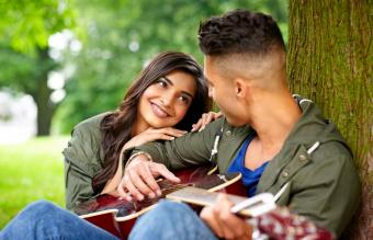 Romantic couple with guitar outdoors