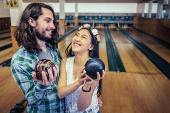 Two millennial friends having fun with bowling, at the bowling alley venue.