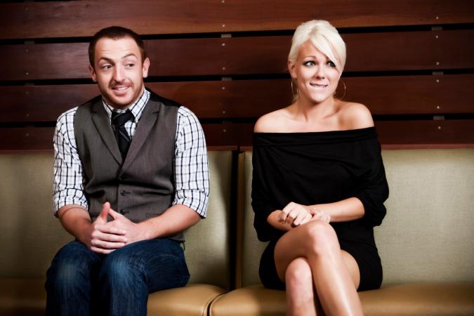 Seated nervous couple on date
