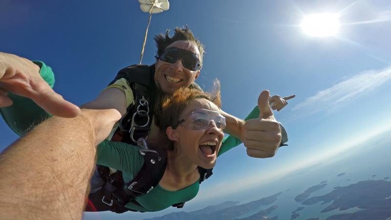 Woman tandem skydiving with instructor