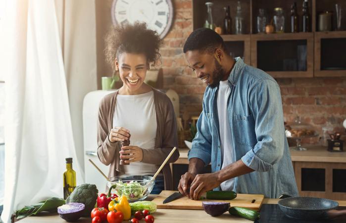 Laughing couple cooking together