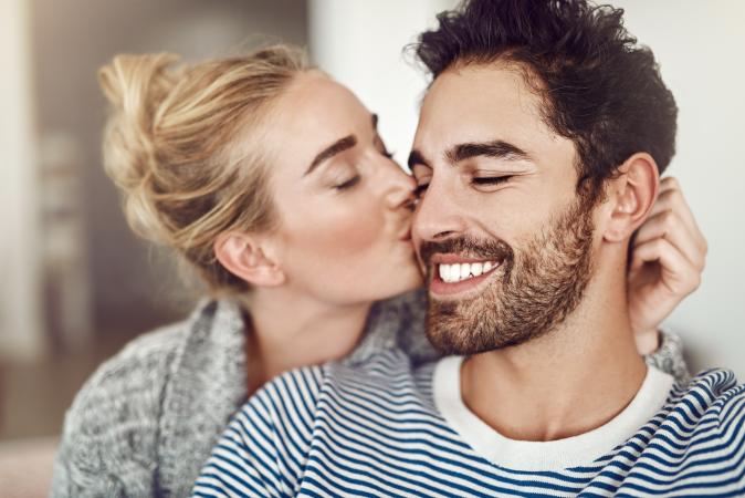 Woman kissing man on cheek