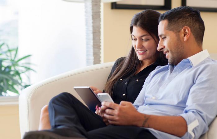 couple using digital tablet in armchair