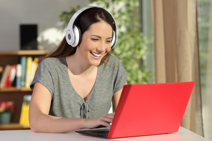 Laughing young woman using laptop