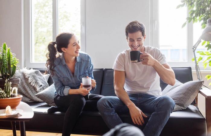 Couple having coffee together in living room