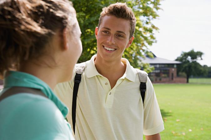 Teen girl and boy flirting outside school