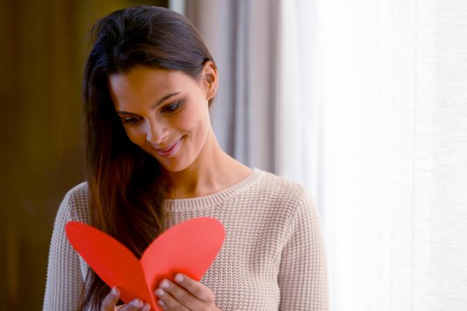 Young woman reading a love note at home