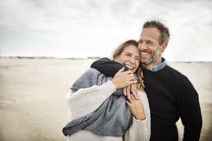 Happy couple hugging on the beach