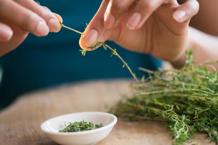 Picking leaves off thyme sprigs