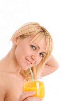 Woman drinking orange juice with straw