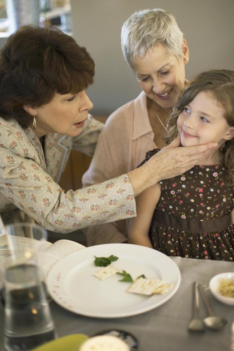 Woman touching child in affectionate way during sedar ritual