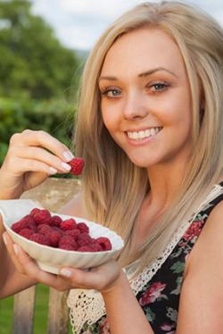 Woman eating raspberries
