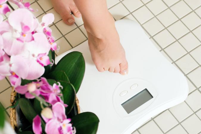 woman stepping on weight scale
