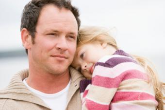 Contemplative father holding daughter