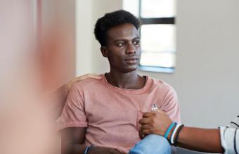 man crying while being consoled 