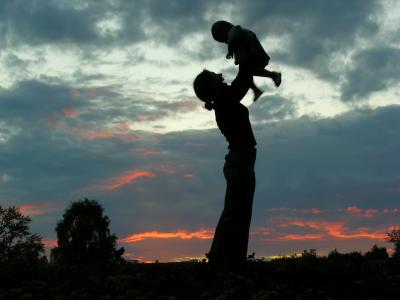 Mother holding baby at sunset
