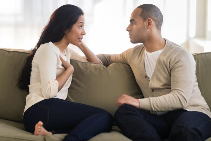 Young couple sitting on couch and having a conversation