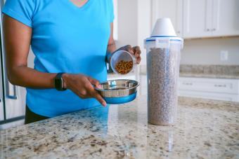 Woman Pours Pet Food Into Bowl 