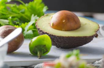 Half avocado on wooden board