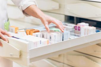 Pharmacist hand taking medication from drawer