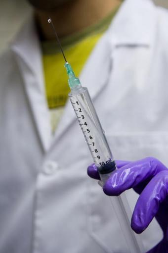 A veterinarian holding a hypodermic syringe