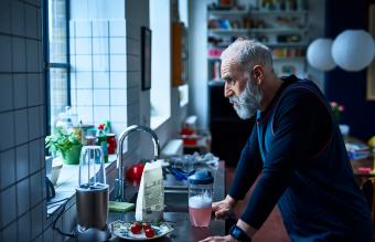 Sad man leaning on kitchen counter