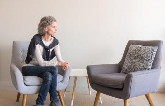 woman seated alone with empty armchair