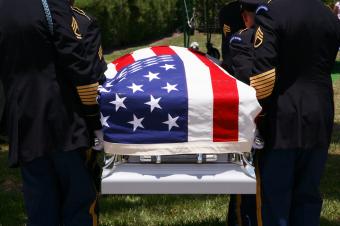 Militaries holding a coffin covered with the American flag