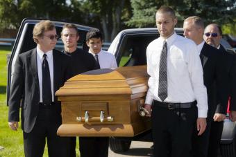 A group of men carrying a casket in a funeral