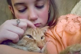 Sad girl petting her cat