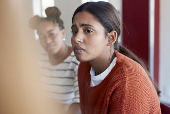 Young woman crying while looking away sitting with friend