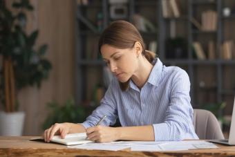 Concentrated young woman writing a letter