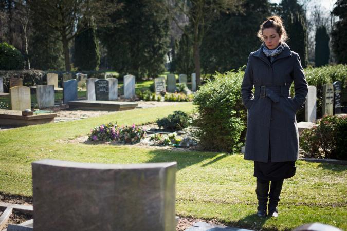 Woman grieving at cemetery