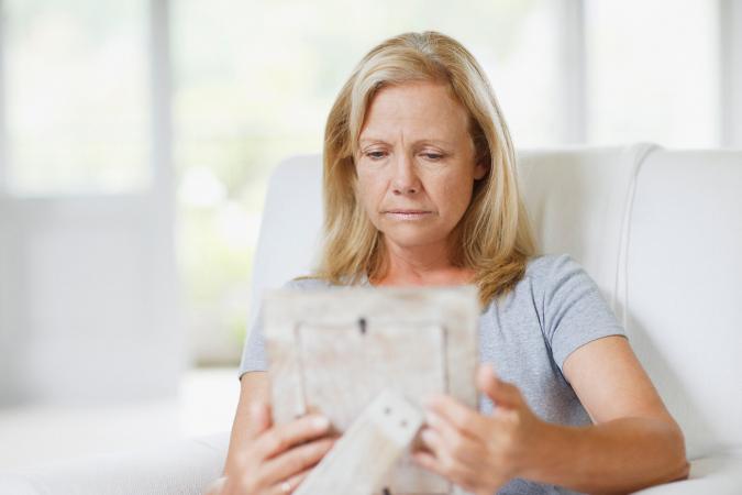 Sad woman holding photo