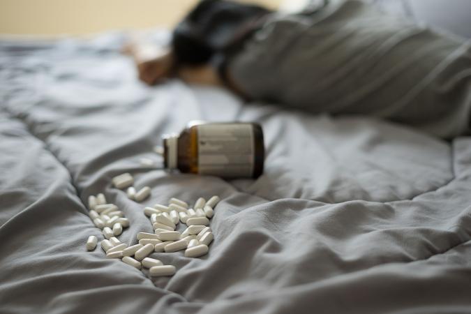 Suicide with medicine tablets on bed